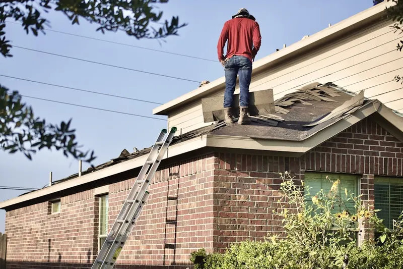 Professional roofer working on a residential roof in Garnier